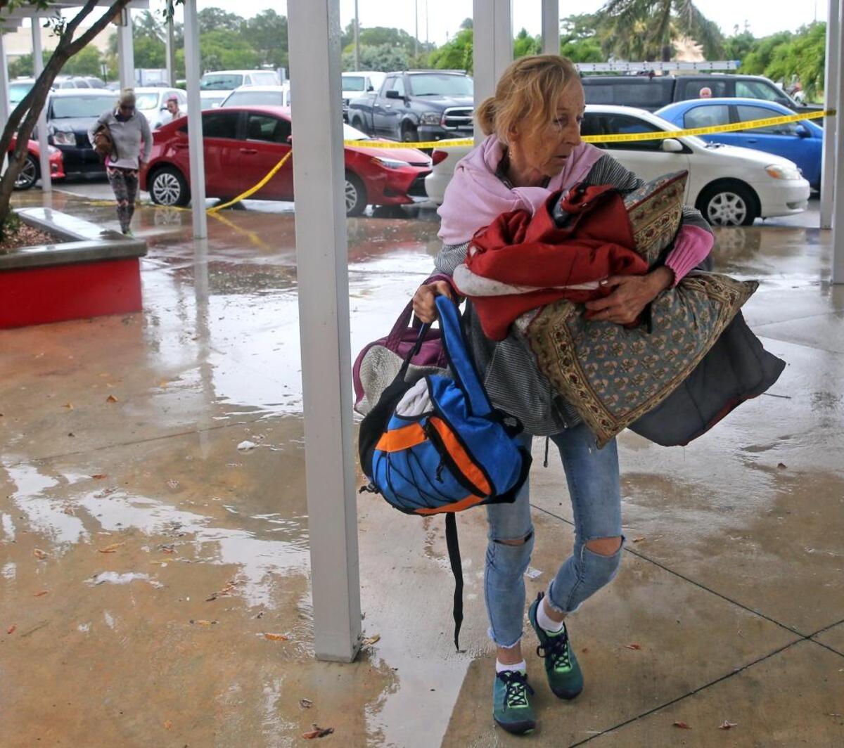 A Key West resident carries bedding and supplies into a shelter at Key West High School as residents sought last-hour refuge from approaching Hurricane Irma.